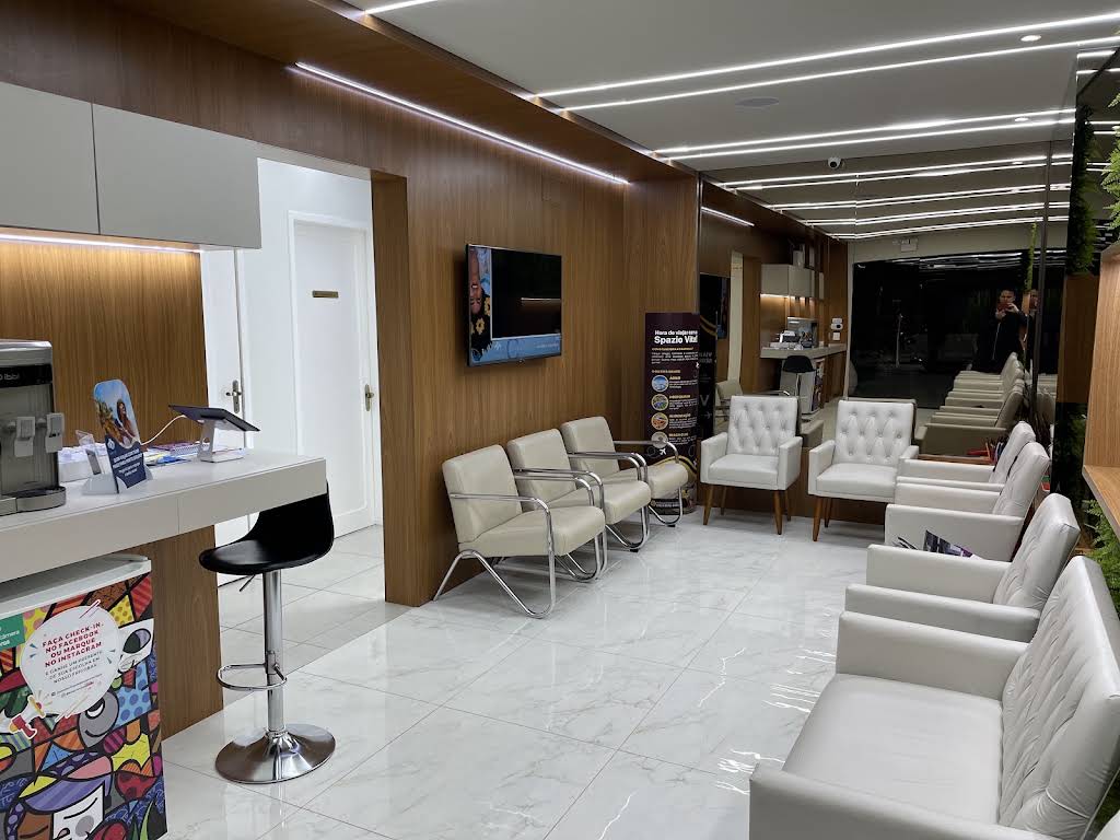 Recepção da Spazio Vita Saúde, com poltronas claras e acabamento em madeira